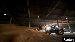 An agricultural worker operates inside a grain storage during a wheat harvesting the in Zaporizhzhia region, Ukraine July 14, 2023. 