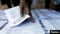 FILE - People search for their names on a voting list during local elections in Phnom Penh, Cambodia June 4, 2017. 