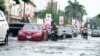 Cars drive on a flooded streets after a heavy downpour in Lagos, Nigeria, July 10, 2024. 