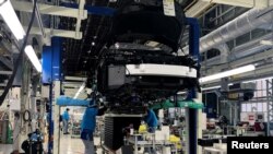 Sejumlah pekerja tampak memasang sistem tenaga sel bahan bakar pada seri Toyota Mirai di pabrik Toyota Motor Corp di Prefektur Aichi, Jepang, pada 11 April 2019. (Foto: Reuters/Joe White)