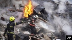 2024年1月23日，乌克兰哈尔科夫的救援人员在被俄罗斯火箭弹损坏的建筑物现场工作。（美联社照片）