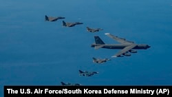 Pesawat pembom B-52H Angkatan Udara AS (tengah), jet-jet tempur F-16, jet tempur F-15K Angkatan Udara Korea Selatan, dan jet tempur F-2 Angkatan Udara Jepang, terbang dalam formasi selama udara gabungan dekat Semenanjung Korea, 22 Oktober 2023.