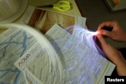Para peneliti memamerkan transparansi tekstil cerdas, yang mengintegrasikan Serat Optik Polimer (POF), bahan yang biasa ditemukan di industri medis dan otomotif, dengan benang, di laboratorium mereka, di Hong Kong, China, 5 Juni 2023. (Foto: Reuters)