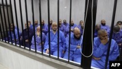 Para tersangka militan kelompok Negara Islam (IS) duduk di bilik terdakwa selama persidangan di kota Misrata, Libya barat laut pada 29 Mei 2023. 