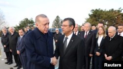 Presiden Turki Recep Tayyip Erdogan (kiri, depan) menjabat tangan pemimpin baru Partai Rakyat Republik (CHP) Ozgur Ozel ketika keduanya menghadiri sebuah acara di Ankara, Turki, pada 10 November 2023. (Foto: Murat Cetinmuhurdar/PPO/Handout via Reuters)
