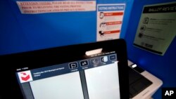 FILE - A touchscreen voting machine and printer are seen in a voting booth in Paulding, Georgia, Nov. 5, 2019.