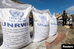 Displaced Palestinians wait to receive United Nations Relief and Works Agency aid during the ongoing conflict between Israel and the Palestinian Islamist group Hamas in Rafah in the southern Gaza Strip, March 7, 2024.