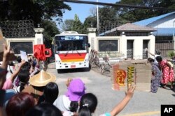 Sebuah bus yang membawa tahanan yang dibebaskan disambut oleh anggota keluarga dan rekannya saat meninggalkan Penjara Insein di Yangon, Myanmar, Kamis, 4 Januari 2024.(AP/Thein Zaw)