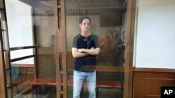 FILE — Wall Street Journal reporter Evan Gershkovich stands in a glass cage in a courtroom at the Moscow City Court in Moscow, Russia, June 22, 2023.