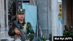 资料照片：缅甸掸邦反政府武装人员在占领的乡镇站岗。（2023年11月9日）