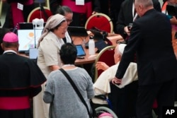 Paus Fransiskus disambut oleh peserta perempuan pada sesi pembukaan Sidang Umum Sinode Para Uskup ke-16 saat ia tiba di Aula Paulus VI di Vatikan, Rabu, 4 Oktober 2023. (AP/Gregorio Borgia)