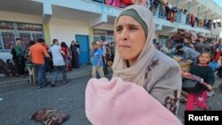 Palestinka ispred u dvorištu škole Ujedinjenih nacija gde su smešteni ljudi koji su napustili domove u severnom delu Pojasa Gaze (Foto: REUTERS/Anas al-Shareef)