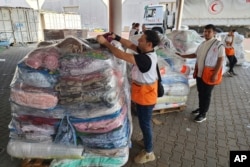 联合国和红新月会的工作人员准备向加沙地带的巴勒斯坦人发放救援物资。（2023年10月23日）