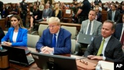 FILE - Former President Donald Trump, center, with attorneys Alina Habba, left, and Chris Kise, waits for continuation of his civil business fraud trial at New York Supreme Court, Oct. 25, 2023. Trump is to testify again in the trial in December.