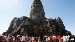 FILE - Tourists line up for stepping up Angkor Wat temple outside Siem Reap, Cambodia, Dec. 31, 2017.
