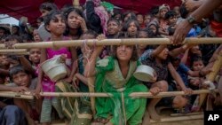 FILE - Rohingya Muslim children refugees, who crossed over from Myanmar into Bangladesh, wait to receive food handouts distributed to children and women by a Turkish aid agency, Oct. 21, 2017, at Thaingkhali refugee camp, Bangladesh.