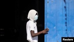 Seorang tahanan berdiri di dekat gerbang Lembaga Pemasyarakatan Nasional Haiti menyusul kerusuhan yang berujung pada aksi pembobolan penjara tersebut di Port-au-Prince, pada 3 Maret 2024. (Foto: Reuters/Ralph Tedy Erol)