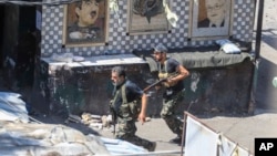 Members of the Palestinian Fatah group run to take position during a third day of clashes that erupted with Islamist factions in the Palestinian refugee camp of Ein el-Hilweh near the southern port city of Sidon, Lebanon, July 31, 2023.