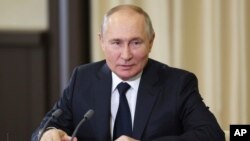 Russian President Vladimir Putin speaks to Gen. Zhang Youxia, vice chairman of China's Central Military Commission during a meeting at the Novo-Ogaryovo residence outside Moscow, Nov. 8, 2023.