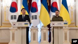 South Korean President Yoon Suk Yeol, left, delivers a statement as Ukrainian President Volodymyr Zelenskyy listens during his surprise visit in Kyiv, Ukraine, July 15, 2023.