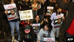 Kerabat dan pendukung memegang plakat bergambar sandera Israel yang ditahan di Gaza sejak serangan Hamas pada 7 Oktober di Israel selatan, dalam unjuk rasa yang menyerukan pembebasan mereka, di Tel Aviv, Israel, 20 Januari 2023.