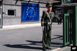 FILE - A Chinese paramilitary policeman stands guard at the entrance to the European Union Delegation to China compound in Beijing, Oct. 14, 2023.