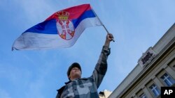 Ilustracija - Učesnik protesta "Srbija protiv nasilja" maše zastavom Srbije (AP Photo/Darko Vojinovic)