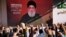 Supporters of the Iranian-backed Hezbollah group raise their fists and cheer as Hezbollah leader Hassan Nasrallah appears via a video link during a rally in Beirut, Lebanon, Nov. 3, 2023. 