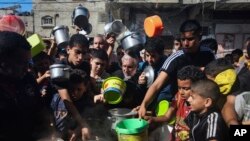 Palestinians crowded together as they wait for food distribution in Rafah, southern Gaza Strip, Nov. 8, 2023.