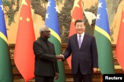Presiden China Xi Jinping dan Perdana Menteri Kepulauan Solomon Manasseh Sogavare berjabat tangan di Aula Besar Rakyat di Beijing, China, 10 Juli 2023. (Foto: cnsphoto via REUTERS)