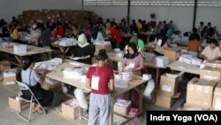 FILE - Penyortiran dan pelipatan surat suara untuk Pemilu 2024 di Gudang KPU Kotamadya Jakarta Timur di Jakarta, 11 Januari 2024. (VOA/Indra Yoga)
