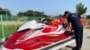 An undated handout photo made available by the South Korean coast guard shows two members in Incheon looking at the personal watercraft Kwon Pyong used to get to South Korea, crossing the Yellow Sea from the Chinese province of Shandong.