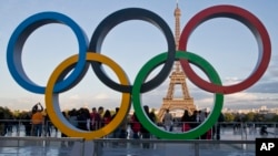 FILE - The Olympic rings are set up in Paris, France, Thursday, Sept. 14, 2017 at Trocadero plaza that overlooks the Eiffel Tower, a day after the official announcement that the 2024 Summer Olympic Games will be in the French capital. 