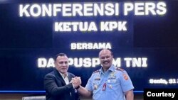 Danpuspom TNI Marsda Agung Handoko dan Ketua KPK Firli Bahuri berjabat tangan setelah konferensi pers soal penetapan dua anggota TNI sebagai tersangka korupsi di Basarnas,Senin (31/7). Keduanya menepis adanya perpecahan diantara kedua badan pimpinan mereka. (Courtesy : Mabes TNI)