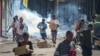 People run with merchandise as crowds leave shops with looted goods amid a state of unrest in Port Moresby, Papua New Guinea, Jan. 10, 2024. The country is discussing security assistance with China, its foreign minister says.