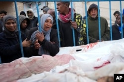 Palestinians mourn relatives killed in an Israeli air and ground offensive on the Gaza Strip at a hospital in Deir al Balah, Jan. 26, 2024.