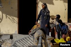 Seorang perempuanPalestina dan seorang anak melihat lokasi serangan udara Israel di sebuah gedung di Rafah di selatan Jalur Gaza, 9 Maret 2024. (Foto: Reuters)