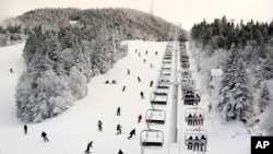 FILE - Skiers descend near the North Ridge Quad chairlift, Nov. 24, 2023, at Killington Ski Resort, in Killington, Vermont.