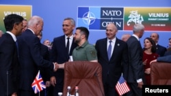 Ukraine's President Volodymyr Zelenskyy and U.S. President Joe Biden shake hands as British Prime Minister Rishi Sunak and NATO Secretary-General Jens Stoltenberg attend a meeting of the NATO-Ukraine council, in Vilnius, Lithuania, July 12, 2023.