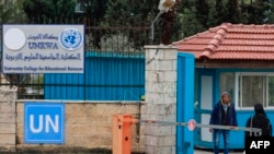 Warga Palestina berdiri di pintu masuk Universitas College for Educational Science kota Ramallah yang dikelola UNRWA di Tepi Barat, 29 Januari 2024. (Jaafar ASHTIYEH / AFP)