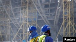 Sejumlah pekerja beraktivitas di lokasi pembangunan stadion Lusail yang disiapkan untuk perhelatan Piala Dunia 2022 di Doha, Qatar. Foto diambil pada 20 Desember 2019. (Foto: Reuters/Kai Pfaffenbach)