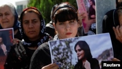  A woman holds a placard during a protest following the death of Mahsa Amini in front of the United Nations headquarters in Erbil, Iraq on September 24, 2022. (Azad Lashkari/Reuters)