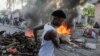 Seorang pria berlari melewati tumpukan barang yang terbakar yang dijadikan barikade dalam aksi protes menentang pemerintah dan kenaikan harga BBM di Port-au-Prince, Haiti, pada 3 Oktober 2022. (Foto: Reuters/Ralph Tedy Erol)