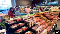 People shop at a grocery store in Glenview, Ill., Monday, July 4, 2022.