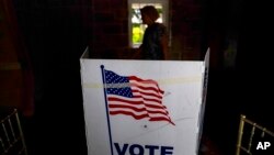 FILE - A person waits in line to vote in the Georgia's primary election, in Atlanta, May 24, 2022