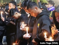 Ribuan pendukung Arema FC yang dikenal sebagai Aremania mendatangi Balai Kota Malang pada Rabu (5/10) malam untuk menggelar acara doa bersama atas insiden Stadion Kanjuruhan pada Sabtu (1/10). (Foto: VOA/Indra Yoga)