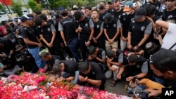 Para pemain dan ofisial klub sepak bola Arema FC berdoa di luar Stadion Kanjuruhan, Malang, yang menyebabkan banyak suporter kehilangan nyawa akibat terinjak-injak pada 3 Oktober 2022. (Foto: AP)