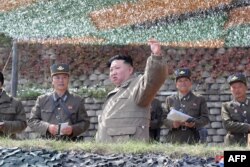 This picture taken on Oct. 8, 2022, and released from North Korea's official Korean Central News Agency (KCNA) on Oct. 10, 2022, shows North Korea's leader Kim Jong Un, center, attending a large-scale air attack training exercise for the Korean People's Army Air Force, at an undisclosed location.