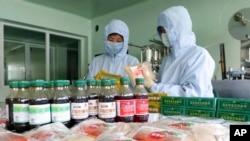 Pegawai dari Pabrik Obat Junggu Koryo tampak menyiapkan koryo, obat tradisional yang digunakan oleh pemerintah Korea Utara dalam melawan COVID, di lokasi pabrik yang terletak di Pyongyang, pada 7 Juni 2022. (Foto: AP/Cha Song Ho)