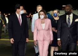 2022年8月2日晚，台湾外交部长吴钊燮（左）在松山机场迎接到访的美国国会众议院议长佩洛西（中）。